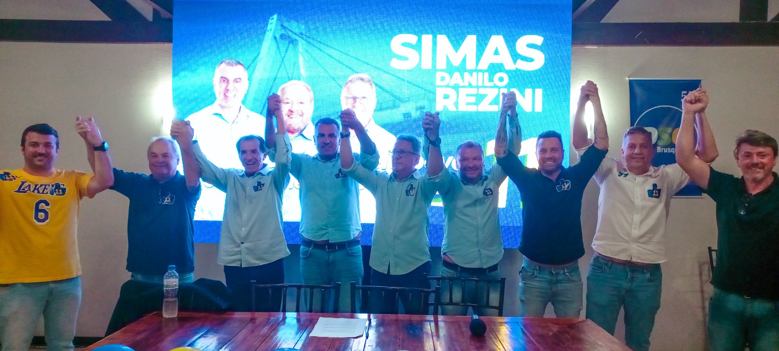 Simas e Danilo Rezini ao lado dos apoiadores na convenção que definiu a chapa. (Imagem: Divulgação).